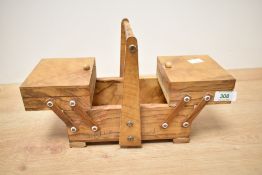 A mid 20th century olive wood concertina sewing box, of small proportions with central carrying