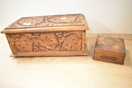 A decorative carved wooden box, of hinged rectangular form carved with foliate designs 15cm x 35cm
