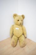 A mid 20th century Straw Filled Yellow Plush Teddy Bear having plastic eyes, stitched nose and mouth