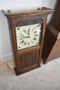 A reproduction oak wall clock, height approx. 82cm