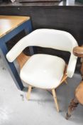A vintage style bent ply carver chair having cream leatherette upholstery