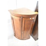 A reproduction oak bow fronted corner cupboard, height approx. 94cm