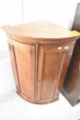 A reproduction oak bow fronted corner cupboard, height approx. 94cm