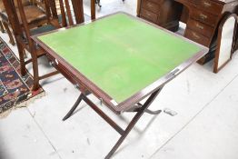 A late Victorian/Edwardian mahogany folding campaign games table having line inlay decoration,