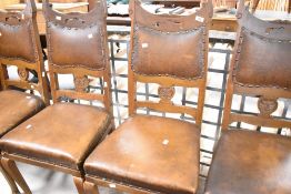 A set of four late 19th or early 20th Century Arts & Crafts oak dining chairs having shaped back
