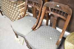 A pair of Victorian oak framed art spindle back chairs having overstuffed seats