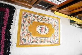 A Chinese fireside rug having mustard ground, approx. 106 x 65cm