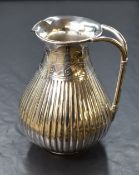 A Victorian silver jug, of bulbous form having a flared rim, small spout and a decorative pierced