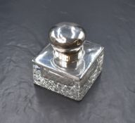A George V silver mounted cut glass inkwell, of square form having a circular cap engraved 'B.P.',