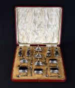 A cased George V silver twelve piece condiment set, comprising four pepperettes, four mustards and