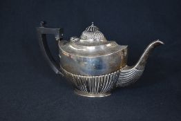 An early George VI silver tea pot, of oval form having a half gadrooned body, raised on an oval