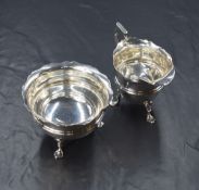 A George V silver sugar and cream, of circular form having Chippendale style rims and moulded