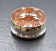 An Elizabeth II silver wine coaster, of traditional form with moulded rim and base, having wooden