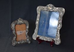 A late Edwardian silver mounted wooden photograph frame, of lobed rectangular form having floral
