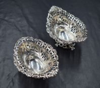 A pair of Victorian silver salts, of oval form having floral scroll rims with pierced diaper