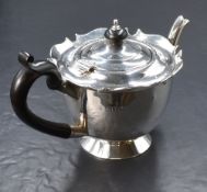 An Edwardian silver bachelors teapot, of circular form having a Chippendale style rim, curved