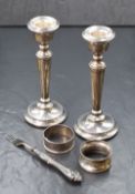 A pair of Elizabeth II silver candlesticks, of traditional form having round moulded sconces, raised