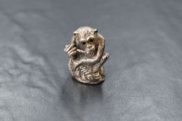 A 20th century silver novelty pin cushion, modelled as a chimpanzee, having glass eyes and red