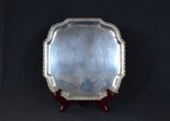 An early George V silver salver, of square form having an egg and dart rim, raised on four hoof
