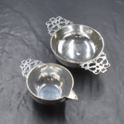 A Victorian silver taste de vin and pouring jug, having decorative pierced handles, raised on a