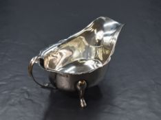 An Elizabeth II silver sauce boat, having a Chippendale style rim and generous spout opposed by a