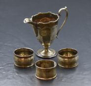 A George V silver cream jug, of fluted form having a decorative moulded rim, narrow spout opposed by