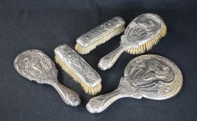 An early George V silver mounted vanity set, comprising a hairbrush, two clothes brushes, a hand