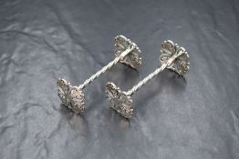 A pair of Edwardian silver knife rests, having twisted centres with pierced quatrefoil ends, marks