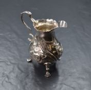 A George II silver cream jug, of traditional form having a Chippendale style rim, shallow spout