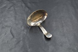 A George III silver caddy spoon, having a vacant shield engraved to the bowl with decorative