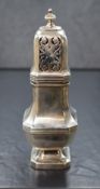 A George V silver sugar caster, having a pierced, finial topped cover over the square canted body,