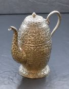 An Eastern white metal teapot, of circular form having a curved spout opposed by a snake motif s-