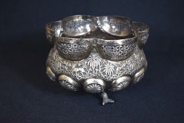 An Eastern white metal bowl, of bulbous lobed form having pierced sections to the rim with fish, the