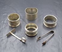 A group of four silver napkin rings, some having engraved monograms and embossed decoration, along