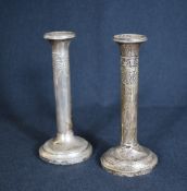 A pair of early George V silver candlesticks, having step moulding to the scones, embossed ribbon