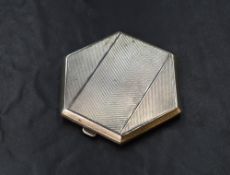 A George VI silver compact, of hinged hexagonal form having engine turned decoration, lacking the