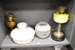 A 19th century oil lamp having embossed yellow glass body with double burners and raised on a