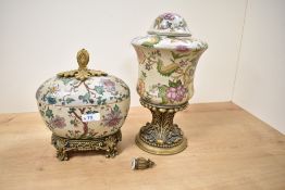 A ceramic oriental style lidded cachepot, decorated with floral patterns and raised on a ormolou