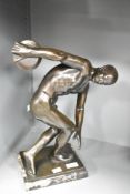 A patinated metal disc thrower sculpture modelled on the original Greek sculpture 'Discobolus',
