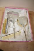 An Art Deco style white metal dressing table set, comprising of hair brush, mirror, comb and further