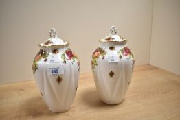 A pair of Royal Albert 'Old Country Rose' pattern vases with covers, having gilt edge and floral