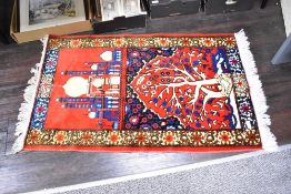 A red Islamic prayer rug/mat, decorated with Mosque and tree within a floral border, L110cm