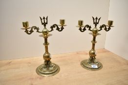A pair of brass turned candlesticks with trident top and a trio sea sepent base, h27.5cm