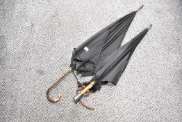 A early 20th century umbrella having palm wood crook handle, L90cm, sold together with 1 other