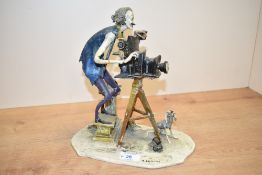 A continental porcelain study of a photographer or film maker having damage to his right arm and