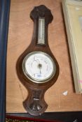 An early 20th century oak barometer having temperature gauge and carved floral patterns, h60cm