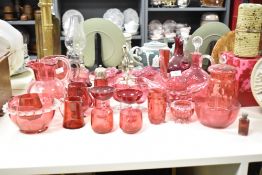 A quantity of cranberry glass ware, to include a oil lamp, sugar shaker and pitcher, (26)