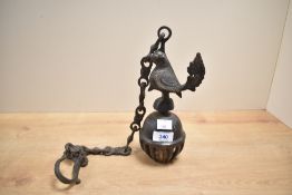 A late 19th or early 20th Century coated brass hanging bell on chain having bird figural