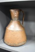 A copper hand hammered ewer having shaped handle and spout, h34cm