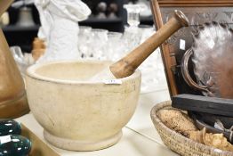 A white stone mortar and pestle having a footed base and wooden handle, h15cm